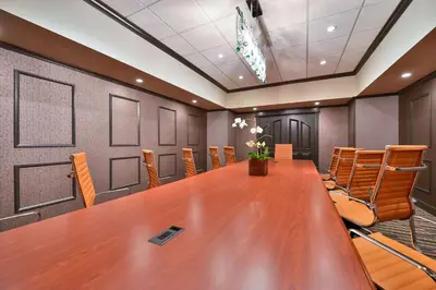 a conference room with a large wooden table and chairs at voco Laguna Hills by IHG in Laguna Hills