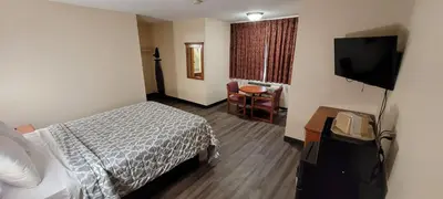 a hotel room with a bed and a flat screen tv at Harvey's Motel SDSU La Mesa San Diego in San Diego