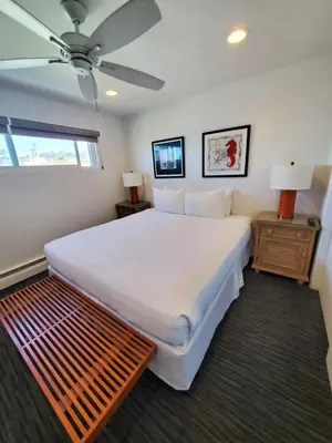 a bedroom with a large white bed and a ceiling fan at Sea Horse Resort in San Clemente