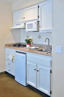 a kitchen with white cabinets and a sink at Old Town Inn in San Diego