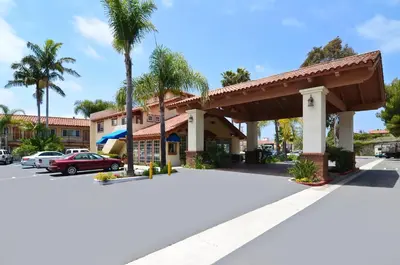 a hotel front of a parking lot with palm trees at Best Western Capistrano Inn in San Juan Capistrano