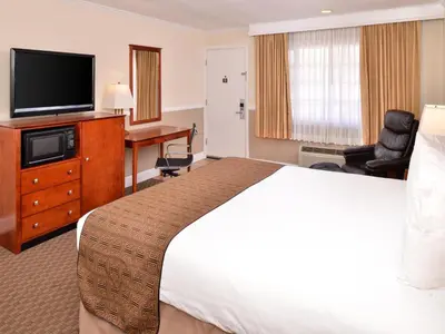 a hotel room with a bed and a flat screen tv at Best Western Capistrano Inn in San Juan Capistrano
