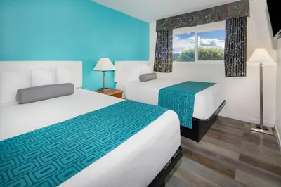 a hotel room with two beds and a window at Howard Johnson Suites by Wyndham San Diego Chula Vista BayFront in Chula Vista