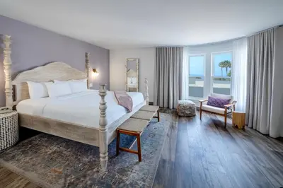 a bedroom with a large bed and a chair at Cardiff By The Sea Lodge in Encinitas
