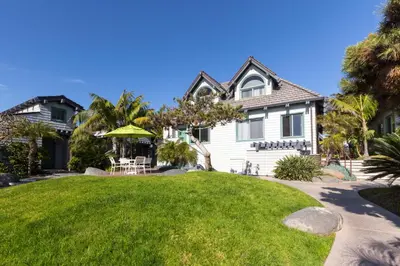 a house with a green lawn in front of it at Wave Crest Resort in San Diego