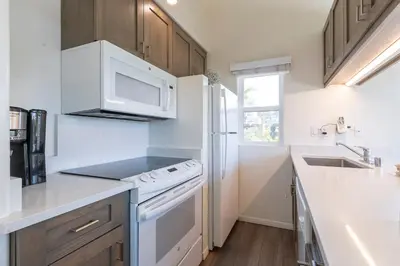 a kitchen with a white stove and a microwave at Wave Crest Resort in San Diego