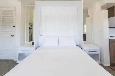 a bedroom with a large white bed with two pillows at Wave Crest Resort in San Diego