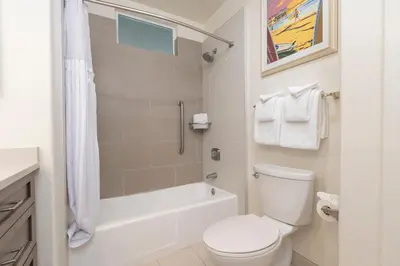 a white bathroom with a toilet and a shower at Wave Crest Resort in San Diego