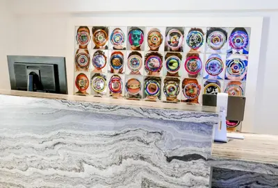 a room with a fireplace with a display of colorful plates at La Jolla Cove Suites in San Diego