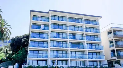 an apartment building with blue balconies and a palm tree at La Jolla Cove Suites in San Diego