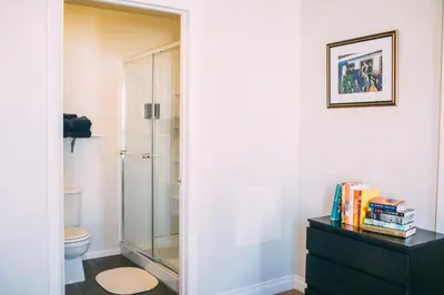 a bathroom with a glass shower and a black dresser at HI San Diego Downtown Hostel in San Diego