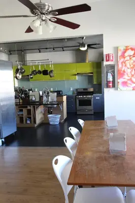 a kitchen with a wooden table and white chairs at HI San Diego Downtown Hostel in San Diego