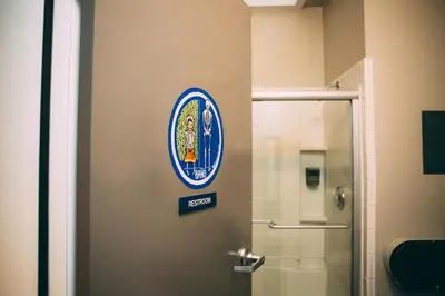 a bathroom door with a corgi crest on it at HI San Diego Downtown Hostel in San Diego