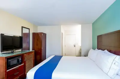 a bedroom with a large bed and a television at GreenTree Inn San Diego Mission Bay in San Diego