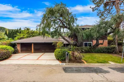 a house with a driveway and a tree at Sunny Dreams Home in San Diego