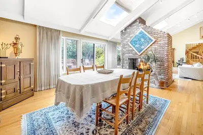 a dining room with a table and chairs and a fireplace at Sunny Dreams Home in San Diego