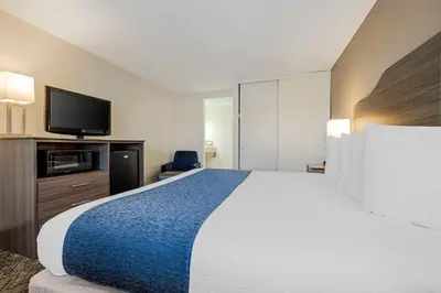 a hotel room with a large bed and a flat screen tv at Best Western Santee Lodge in Santee