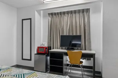 a bedroom with a desk with a television and a chair at Motel 6-San Diego, CA - North in San Diego