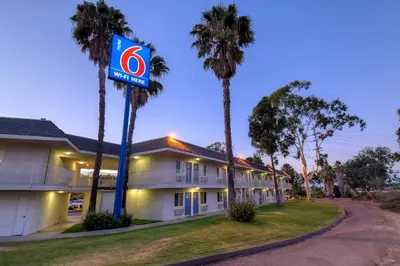 a building with a no parking sign next to palm trees at Motel 6-San Diego, CA - North in San Diego