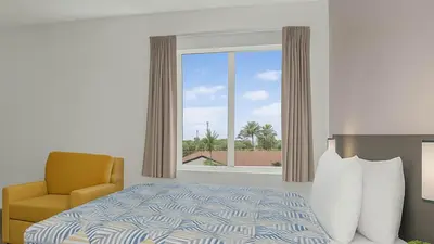a bedroom with a bed and a chair and a window at Motel 6-San Diego, CA - Downtown in San Diego