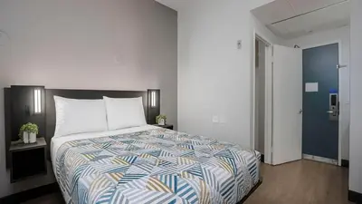 a bedroom with a large bed with a colorful comforter at Motel 6-San Diego, CA - Downtown in San Diego