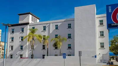 a white building with palm trees in front of it at Motel 6-San Diego, CA - Downtown in San Diego