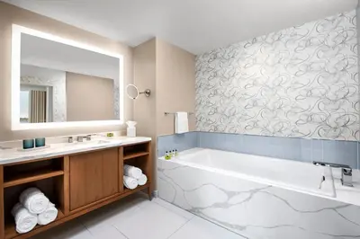 a bathroom with a tub and a sink and a mirror at InterContinental San Diego by IHG in San Diego