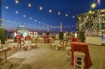 a patio with tables and chairs and a cruise ship at InterContinental San Diego by IHG in San Diego