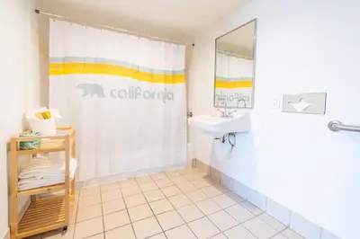 a bathroom with a shower curtain and a sink at Rambler Hotel in Chula Vista