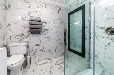 a bathroom with a toilet and a glass shower at Fantastic Mission Beach condo steps to the Beach in San Diego
