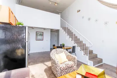 a living room with a chair and stairs at Little Italy Modern Lofts in San Diego