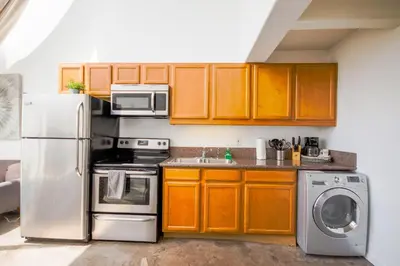 a kitchen with stainless steel appliances and wooden cabinets at Little Italy Modern Lofts in San Diego