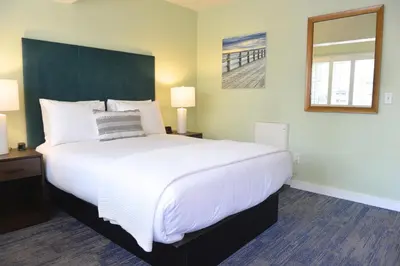 a large white bed in a room with two lamps at Crown City Inn Coronado in San Diego
