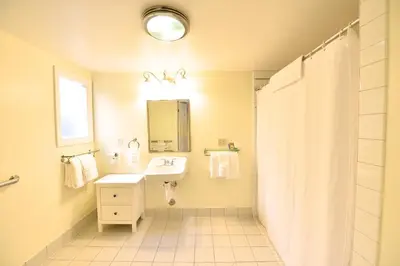 a white bathroom with a sink and a mirror at Crown City Inn Coronado in San Diego