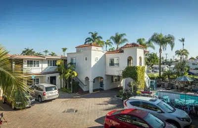 a large white house with cars parked in front of it at Crown City Inn Coronado in San Diego