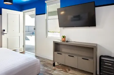 a bedroom with a bed and a flat screen tv at Pacific View Inn in San Diego