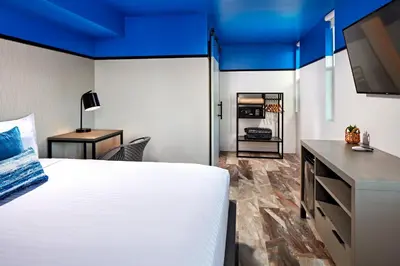 a bedroom with a large white bed and a tv at Pacific View Inn in San Diego