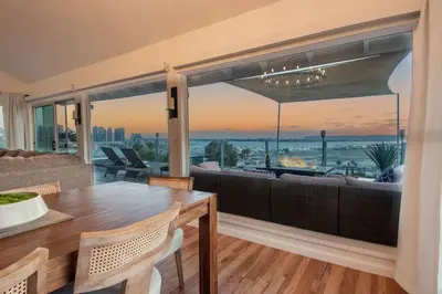 a living room with a table and a large window at Luxury Retreat • Hot Tub FirePit Panoramic Views in San Diego