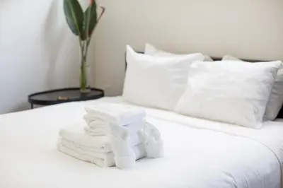 a pile of towels sitting on top of a bed at Abpopa Hillcrest in San Diego