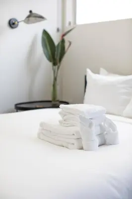 a pile of towels sitting on a bed at Abpopa Hillcrest in San Diego