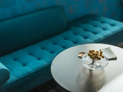 a table with a bowl of flowers on it with a blue couch at Abpopa Hillcrest in San Diego