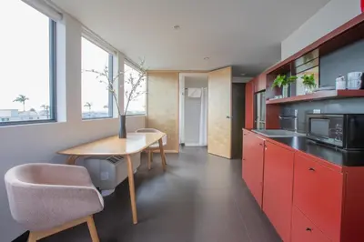 a kitchen with red cabinets and a wooden table at Abpopa Hillcrest in San Diego