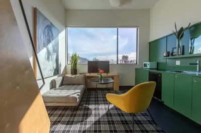 a kitchen with green cabinets and a couch and a table at Abpopa Hillcrest in San Diego