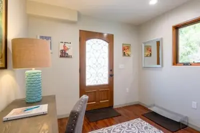 a room with a table with a lamp and a door at The Little Pumpkin Guest House in San Diego
