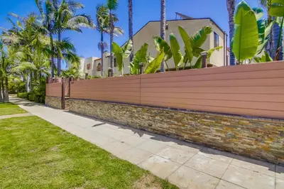 a fence in front of a house with palm trees at PACIFIC BEACH MANSION in San Diego