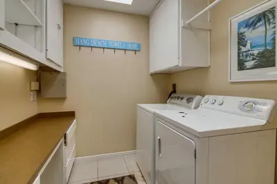 a laundry room with a washer and a sign on the wall at PACIFIC BEACH MANSION in San Diego