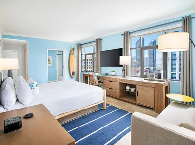 a hotel room with a large bed and a desk at Margaritaville Hotel San Diego Gaslamp Quarter in San Diego