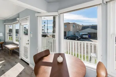 a living room with a table and a balcony at Pacific Bungalow in Oceanside with Backyard & Tiny House in Oceanside
