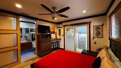 a living room with a couch and a ceiling fan at Kaza Kokos in Oceanside