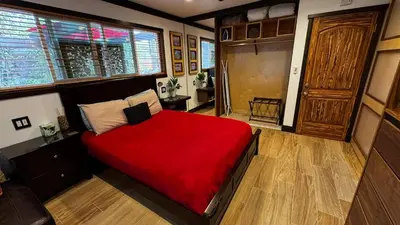 a bedroom with a bed with a red blanket at Kaza Kokos in Oceanside